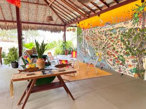 a room with a table and chairs and a mural at Casa Ingapura Suite Tainha - Povoado Bar da Hora 15 min de canoa para Atins - Estilo B&B - Café da Manhã Simples - Conforto in Atins