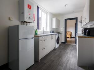 una cocina con refrigerador y lavadora y secadora en Chatham lodge Cosy Large Double Room 1, en Stoke on Trent