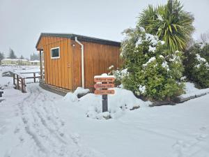 a sign in the snow in front of a cabin at Moonbeam Nights - Kitchenette Parking Sleeps 3 in Lake Tekapo
