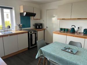 a kitchen with a table and a kitchen with a table and chairs at The Quarters, Kirkwall in Orkney