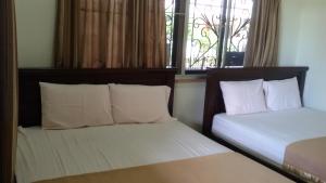 מיטה או מיטות בחדר ב-Vynn's @ Banda Kaba