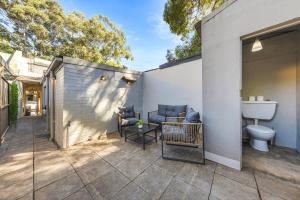 patio trasero con aseo y sofá en Cozy House near Darling Harbor, en Sídney