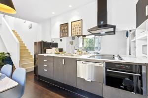 Una cocina con electrodomésticos de acero inoxidable y una escalera. en Cozy House near Darling Harbor, en Sídney