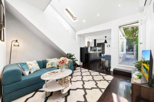 Una sala de estar con un sofá azul y una mesa. en Cozy House near Darling Harbor, en Sídney