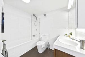 Un baño blanco con inodoro y lavabo. en Cozy House near Darling Harbor, en Sídney 6 fotos más