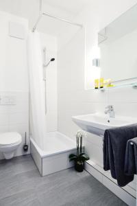 een witte badkamer met een wastafel en een toilet bij Heimat St. Pauli in Hamburg