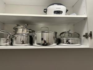 a bunch of pots and pans on a shelf at 4 Guests, 2 bedrooms, 2 queen beds basement apartment in Ajax in Ajax +9 photos