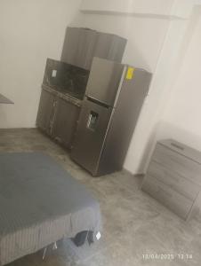 a kitchen with a refrigerator and a bed in a room at Depa in Mazatlán
