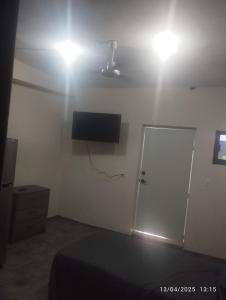 a room with a flat screen tv and a door at Depa in Mazatlán