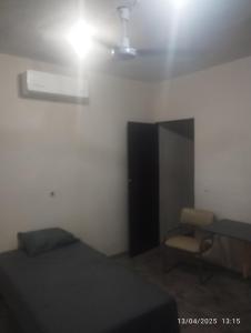 a bedroom with a bed and a chair and a light at Depa in Mazatlán