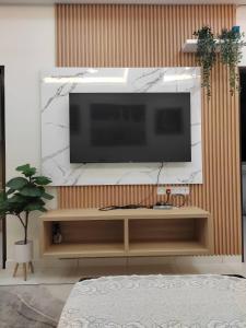 a living room with a flat screen tv on a wall at Ana Homestay in Seri Manjung +2 photos