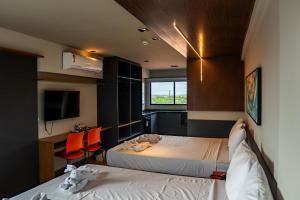 a hotel room with two beds and a tv at Easy Porto Hotel in Porto De Galinhas +60 photos