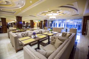 a restaurant with couches and tables in a lobby at Hotel Atlas in Dushanbe