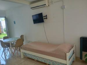 a bedroom with a bed and a table and a tv at Bethel Alojamiento in Zapala