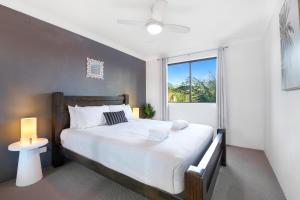 a bedroom with a large bed and a window at Hawaiian Gardens 17 in Coffs Harbour +14 photos
