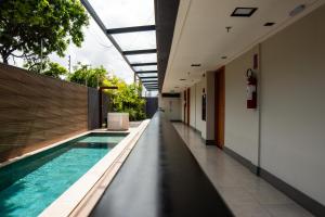an indoor swimming pool in a building with a corridor at Easy Porto Hotel in Porto De Galinhas