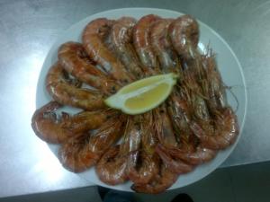 a plate of sausages with a lemon on it at Domus Viatoris in Sahagún