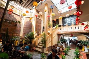 フエにあるPerfume Homestay Huếのランタンのある建物の中でテーブルに座っている人々