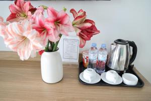 a table with a tray with a vase of flowers and drinks at Hùng Vương Hotel Hạ Long in Ha Long