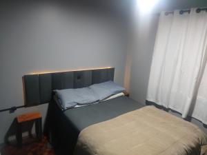 a small bedroom with a bed and a window at Recanto Arvoredo casa 3 quartos piscina garagem e NF para 12 hospedes in Concordia