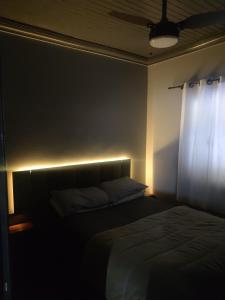 a bedroom with a bed and a window with a light at Recanto Arvoredo casa 3 quartos piscina garagem e NF para 12 hospedes in Concordia