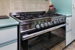 a stainless steel stove in a kitchen at Korora Coastal Escape in Kororo Basin