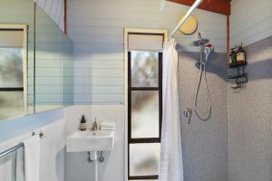 a bathroom with a sink and a shower at Ocean Breeze - Sleeps 12 - Pet Friendly in Scamander +24 photos