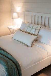 Una cama blanca con dos almohadas encima. en Historic Cottage with private Hiking trails & private waterfront, en Hindmarsh Island