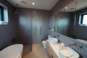 une salle de bain avec deux lavabos et un WC et un miroir dans l'établissement Waterfront Luxury Villa- Private, Nature, Island, à Hindmarsh Island