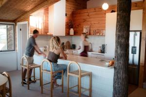 a man and a woman sitting at a kitchen counter at Coastal Tree House- Short Stroll to Beach in Encounter Bay