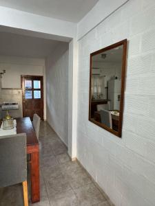 ein Zimmer mit einem Spiegel an einer weißen Wand in der Unterkunft Victoria Apart in Esquina