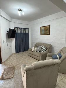 ein Wohnzimmer mit zwei Sofas und einem Flachbildfernseher in der Unterkunft Victoria Apart in Esquina + 11 Fotos