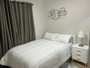 a bedroom with a bed and a table with a lamp at DeHaven in Edmonton