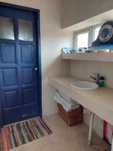 a bathroom with a sink and a blue door at Casa camarones in Camarones