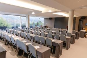 a conference room with tables and chairs and a screen at 莫干山缦田生态度假酒店 in Deqing +25 photos