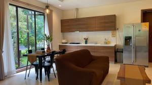 a kitchen with a dining table and a refrigerator at Luxurious Modern Villa at Vimala Hills in Bogor