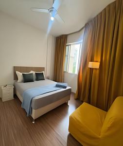 une chambre avec un lit, une fenêtre et un canapé dans l'établissement Localização Ícone em Copacabana! Atrás do Palace, 30m Metrô e Praia, à Rio de Janeiro