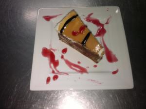 a piece of cake on a white plate with red sauce at Domus Viatoris in Sahagún