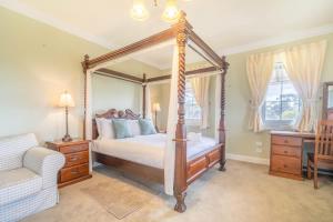 a bedroom with a four poster bed and a couch at 6B Luxury Rustic Farm Manor In Lang Lang in Lang Lang