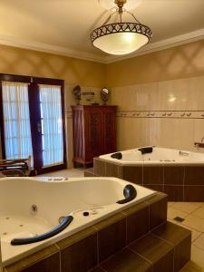 a large bathroom with two large tubs in it at Overdale Luxury Spa Suite in Harefield