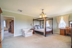 a bedroom with a canopy bed and a chair at 6B Luxury Rustic Farm Manor In Lang Lang in Lang Lang
