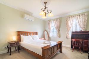 a bedroom with a bed and a desk and a piano at 6B Luxury Rustic Farm Manor In Lang Lang in Lang Lang
