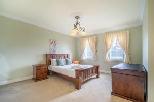 a bedroom with a bed and a dresser and windows at 6B Luxury Rustic Farm Manor In Lang Lang in Lang Lang