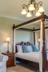 a bedroom with a large canopy bed with blue pillows at 6B Luxury Rustic Farm Manor In Lang Lang in Lang Lang