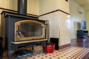 an old fireplace in a room with a floor at 6B Luxury Rustic Farm Manor In Lang Lang in Lang Lang