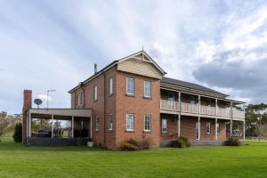 a large brick building on a grass field at 6B Luxury Rustic Farm Manor In Lang Lang in Lang Lang
