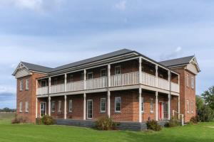 a large red brick building with a balcony at 6B Luxury Rustic Farm Manor In Lang Lang in Lang Lang