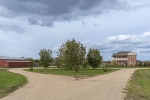 a dirt road in front of a house and a building at 6B Luxury Rustic Farm Manor In Lang Lang in Lang Lang