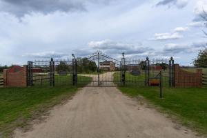 a gate in a field with a roller coaster at 6B Luxury Rustic Farm Manor In Lang Lang in Lang Lang