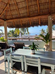 a table and chairs under a straw umbrella on a beach at Casa Punta Perula Boutique Hotel in Pérula